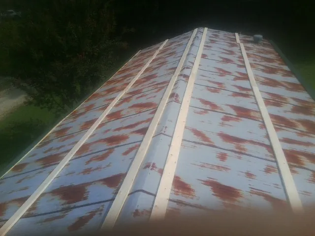 Rusted metal roof panels with new wood purlins before replacement — Storm Damage Roof Repair in Hustonville by Roofing Brothers