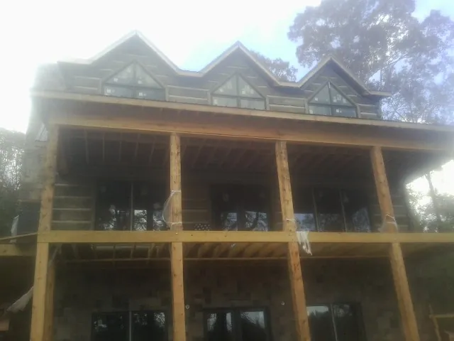 Dormers and porch framing on a large log home under construction — Roof Coating work by our crew in Hustonville