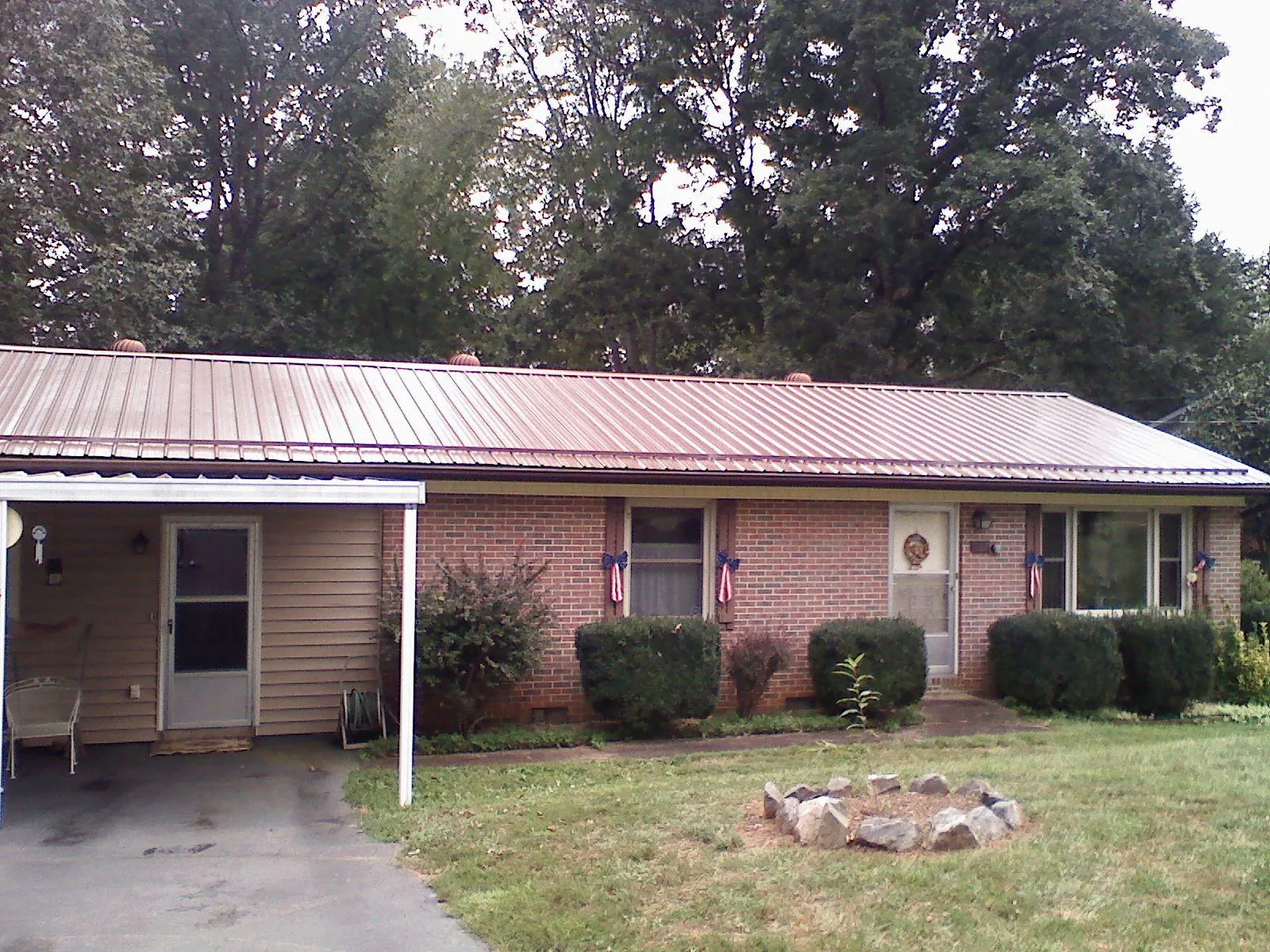 Bronze metal roof and carport on a brick ranch home — Roof Repair work by our crew in Hustonville